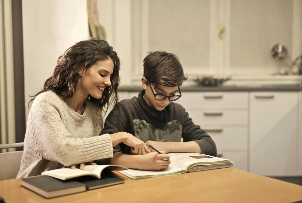 Home Tutor helping student to solve maths problems at home.