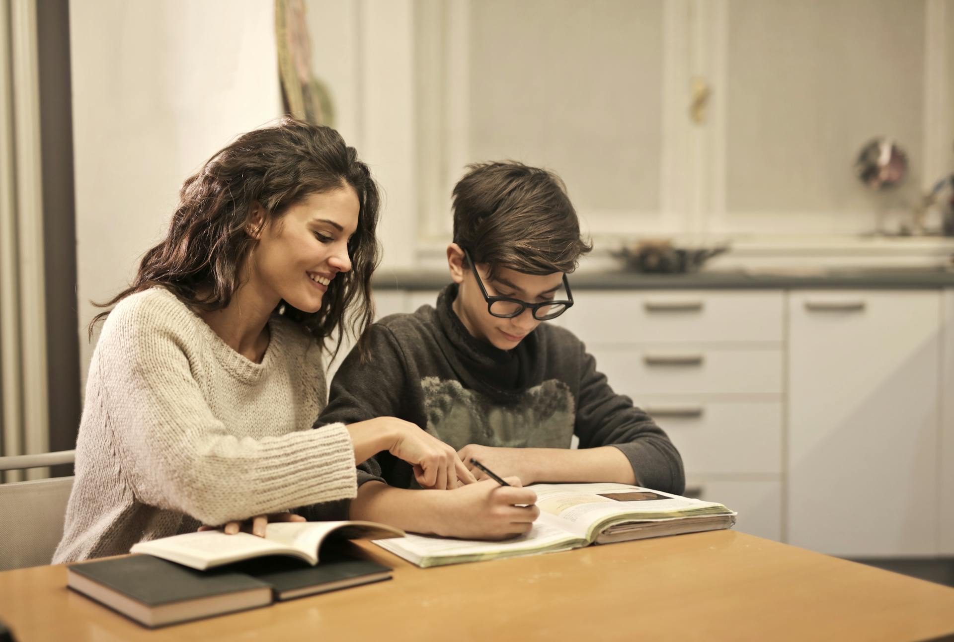Home Tutor helping student to solve maths problems at home.