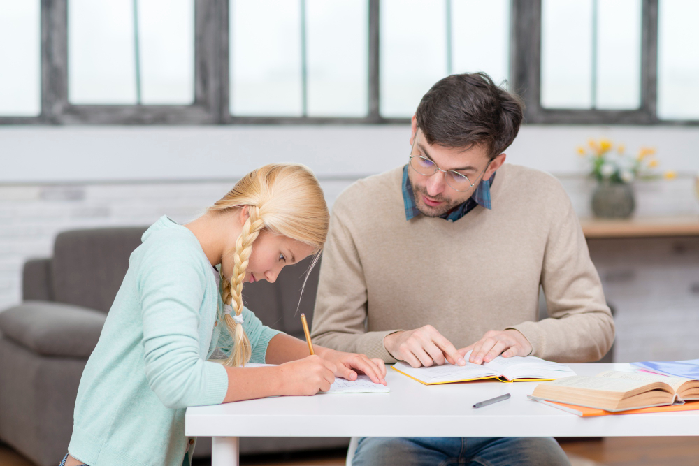 A high school student confidently solving a problem while a private home tutor in Dubai provides one-on-one guidance